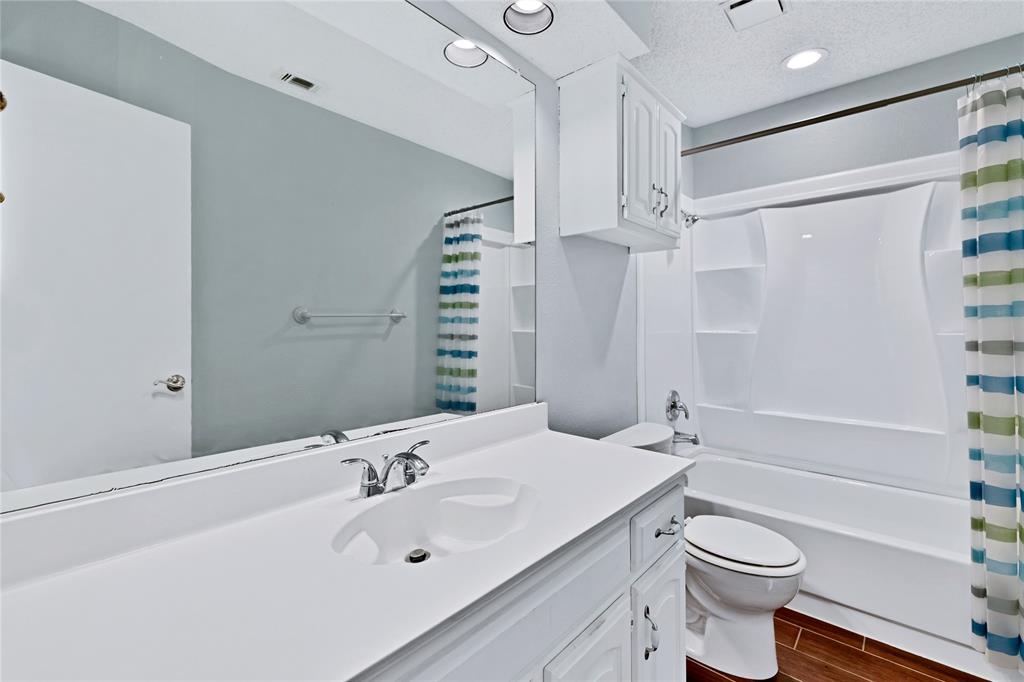 710 Cimarron Trail Irving, TX 75063 - Photo 30 of 39 a bathroom with a sink a toilet and shower