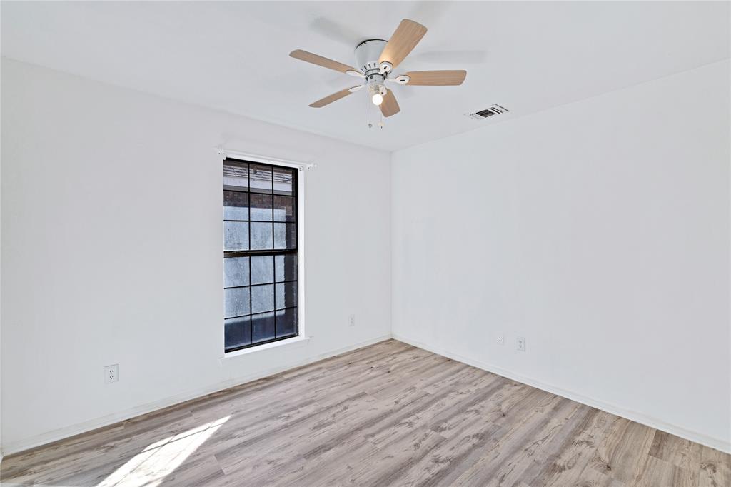 710 Cimarron Trail Irving, TX 75063 - Photo 31 of 39 an empty room with wooden floor closet and windows