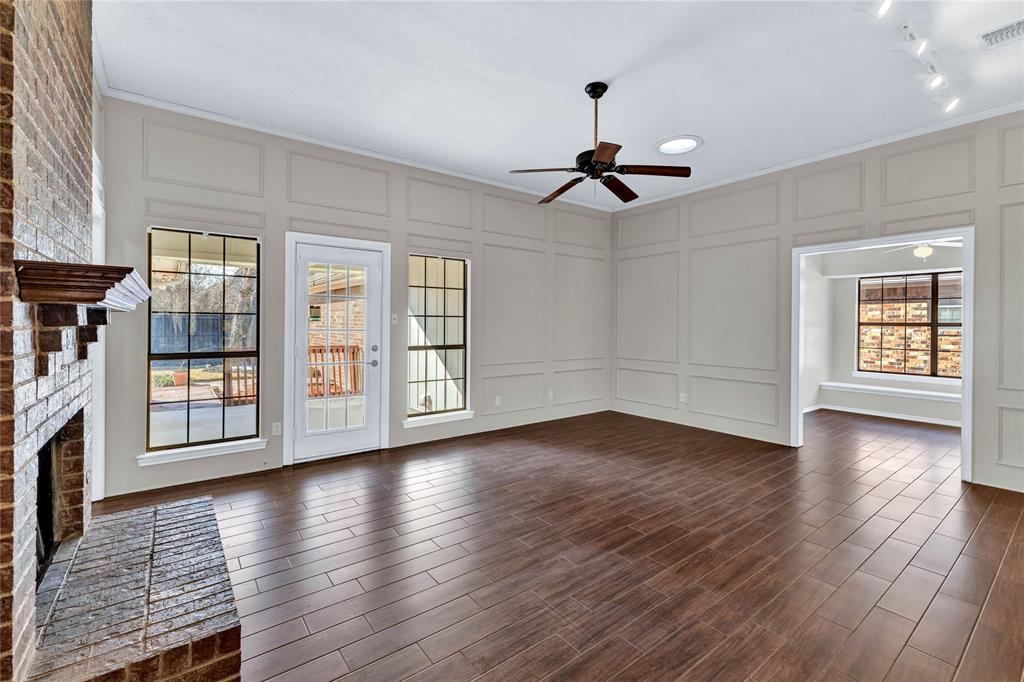 710 Cimarron Trail Irving, TX 75063 - Photo 4 of 39 a view of an empty room with wooden floor and a window