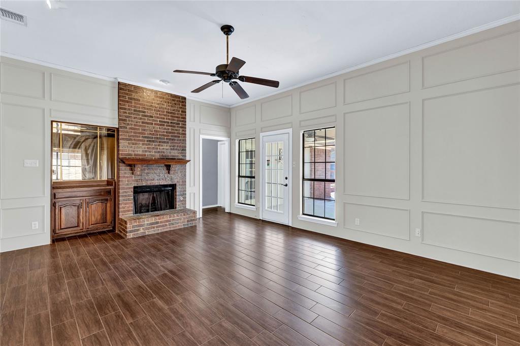 710 Cimarron Trail Irving, TX 75063 - Photo 6 of 39 a view of an empty room with wooden floor fireplace and a window
