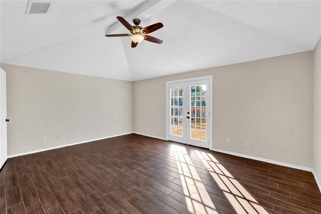 710 Cimarron Trail Irving, TX 75063 - Photo 9 of 39 a view of an empty room with wooden floor and a window