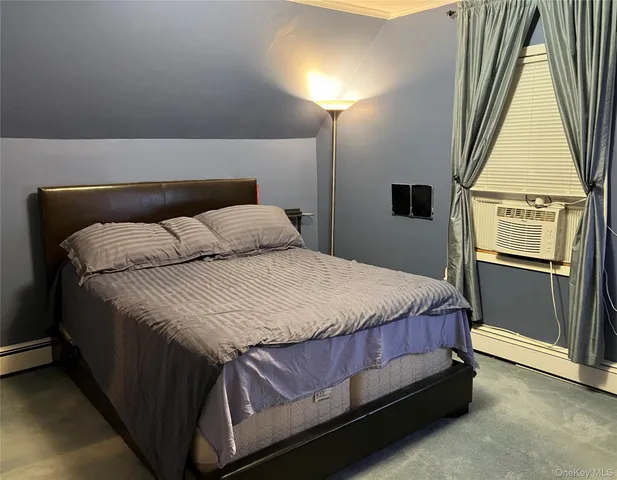 a bedroom with a bed next to a window