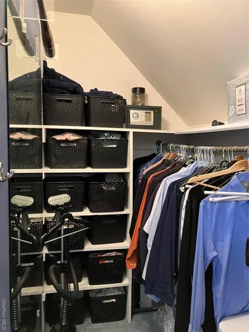 a view of walk in closet with clothes and shoes