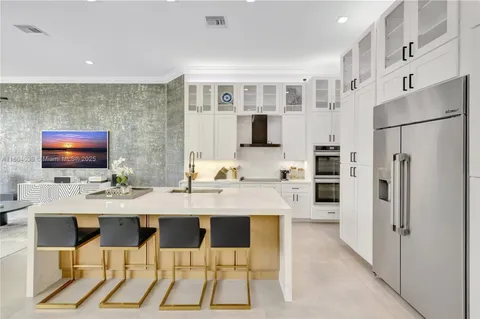 a kitchen with stainless steel appliances kitchen island granite countertop a refrigerator and a stove top oven
