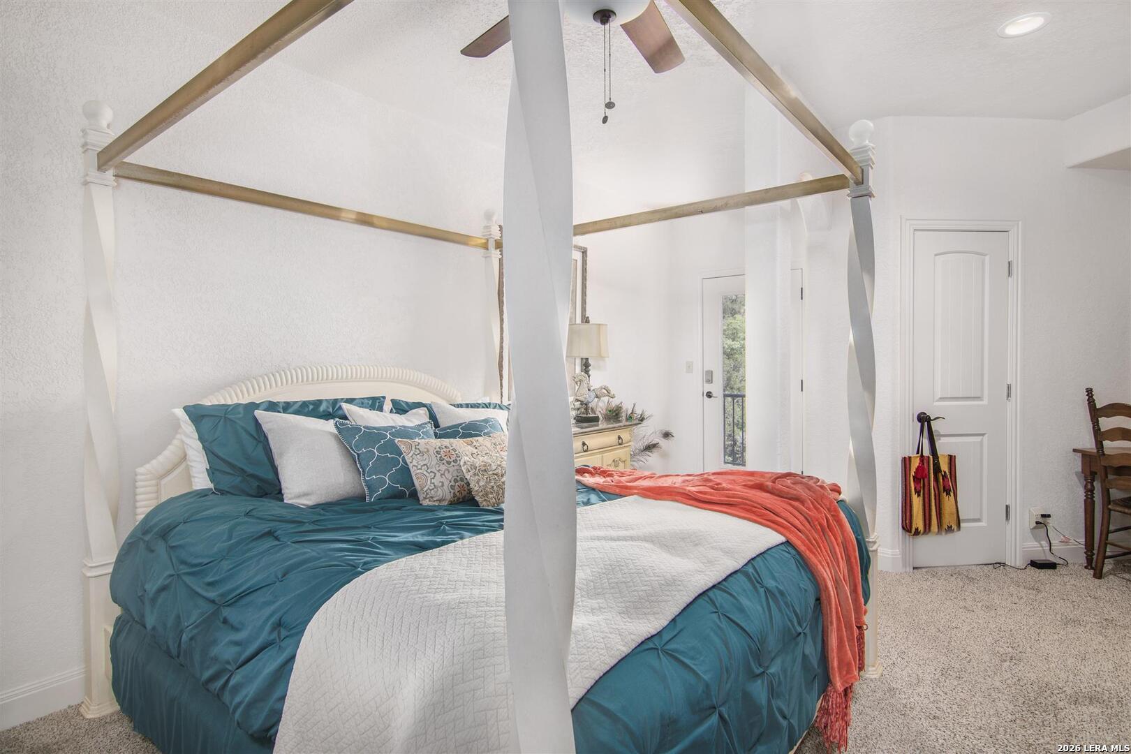 9469 Canyon Mist Helotes, TX 78023 - Photo 46 of 50 a bedroom with a large bed and a chandelier