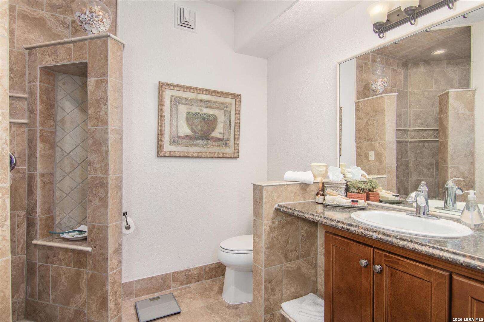 9469 Canyon Mist Helotes, TX 78023 - Photo 47 of 50 a bathroom with a granite countertop sink toilet and shower