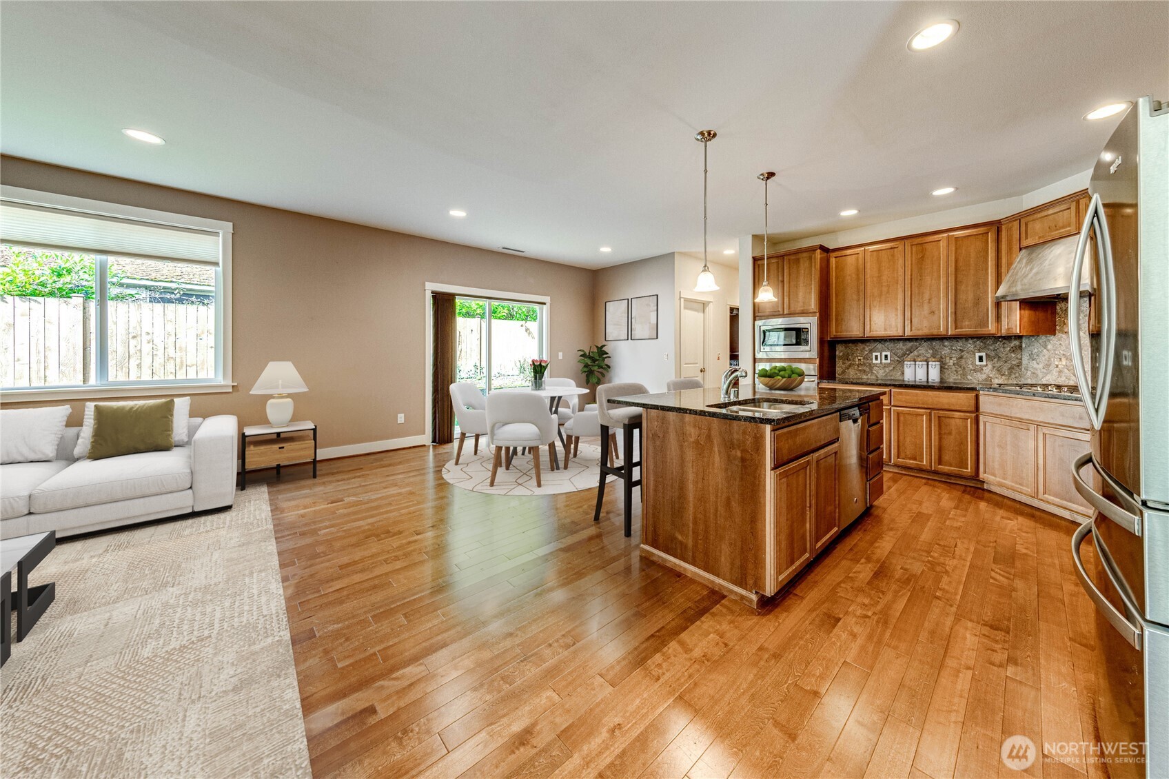 21914 78th Place West Edmonds, WA 98026 - Photo 8 of 39 a kitchen with stainless steel appliances granite countertop a stove top oven a sink dishwasher a dining table and chairs with wooden floor