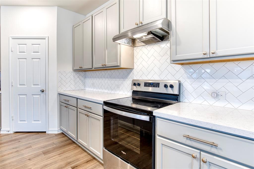 2513 Wayne Avenue Aubrey, TX 76227 - Photo 11 of 27 a kitchen with a stove and white cabinets