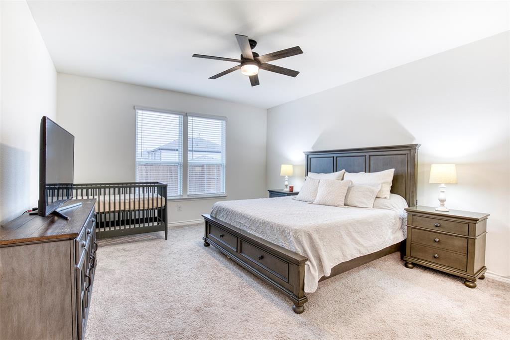 2513 Wayne Avenue Aubrey, TX 76227 - Photo 16 of 27 a spacious bedroom with a bed and a chandelier
