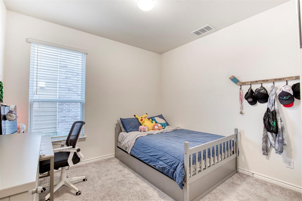 2513 Wayne Avenue Aubrey, TX 76227 - Photo 24 of 27 a bedroom with a bed a desk and chair with the potted plant