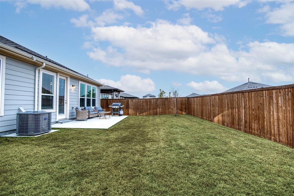 2513 Wayne Avenue Aubrey, TX 76227 - Photo 26 of 27 a view of a backyard with table and chairs potted plants and wooden fence