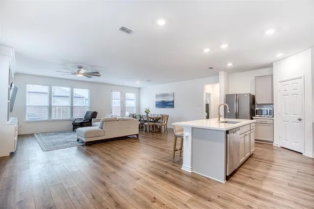 a kitchen with a refrigerator a sink and a stove top oven