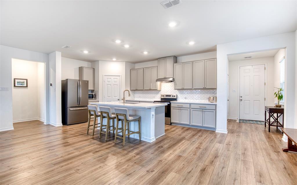2513 Wayne Avenue Aubrey, TX 76227 - Photo 9 of 27 a kitchen with a refrigerator a sink and a stove top oven