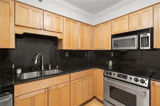 a kitchen with stainless steel appliances granite countertop a sink stove and cabinets