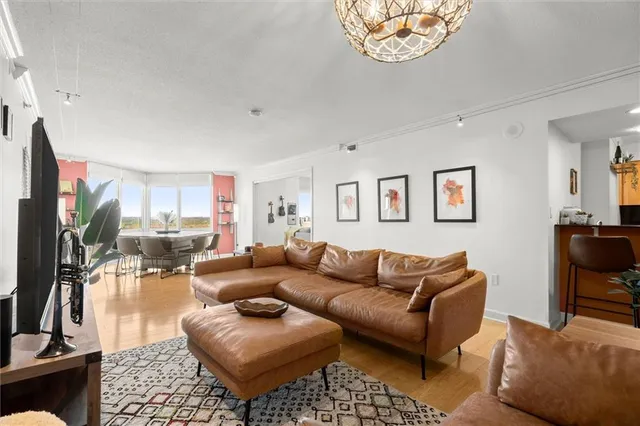 a living room with furniture a potted plant and a large window