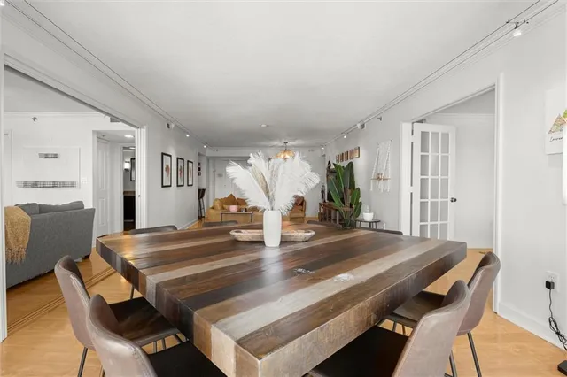 a living room with furniture a chandelier and wooden floor