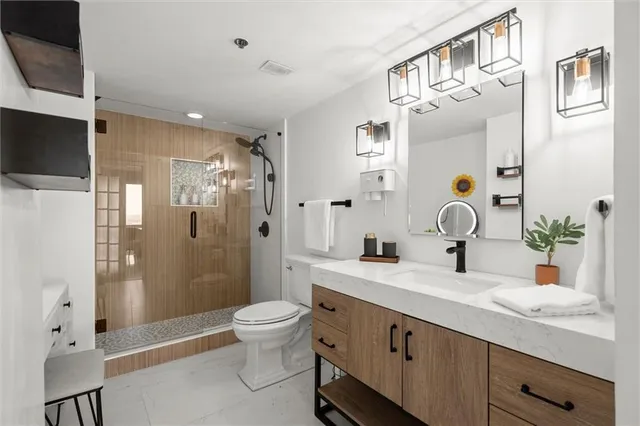 a bathroom with a sink a toilet and shower