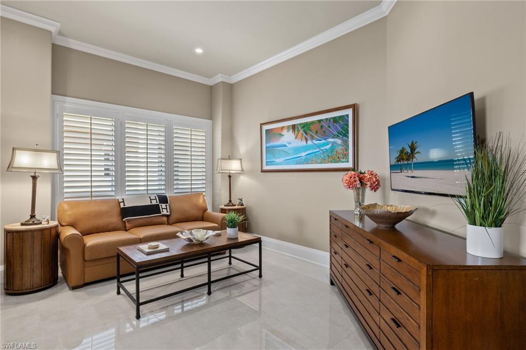 1620 Star Point Lane, Unit 1102 Naples, FL 34112 - Photo 11 of 50 Living room featuring light tile patterned floors, ornamental molding, and ceiling fan with notable chandelier
