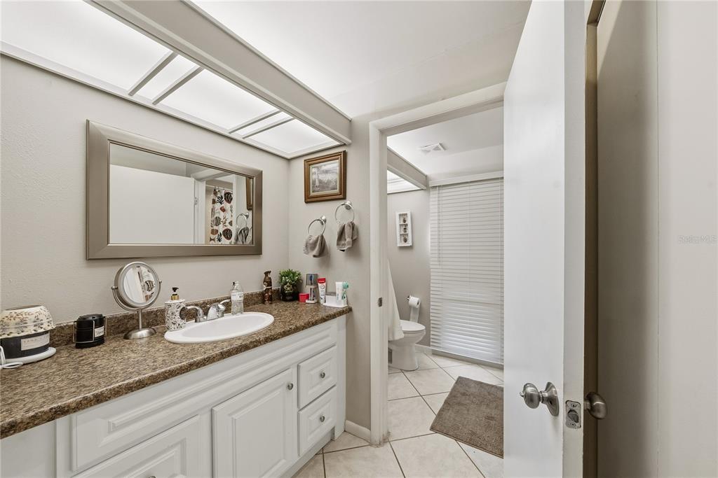 2507 Bluegrass Street Inverness, FL 34453 - Photo 18 of 30 a bathroom with a granite countertop sink mirror vanity and toilet