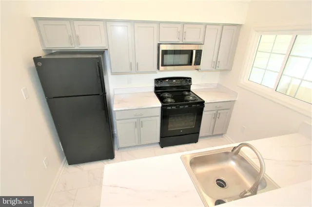 a kitchen with a refrigerator sink and stove