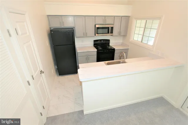 a kitchen with a sink a stove and a window