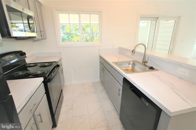a bathroom with a sink a large mirror and a window