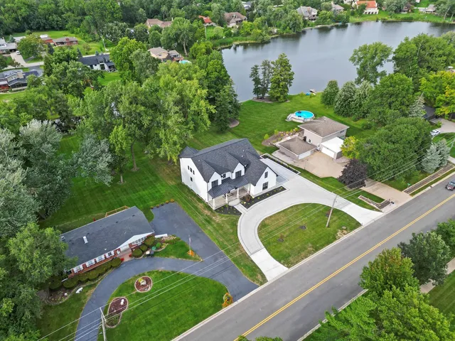 a large kitchen with kitchen island a stove a refrigerator a sink dishwasher and a fireplace with wooden floor