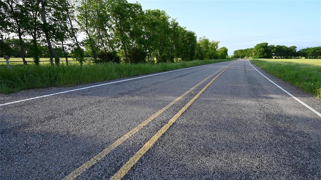 1752 Rd Whitewright Tx 75491 Road Whitewright, TX 75491 - Photo 7 of 12 a view of a street with a yard and large trees