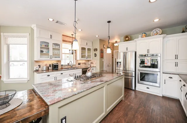 a kitchen with stainless steel appliances granite countertop a stove and cabinets