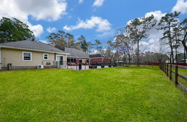 a view of a house with a big yard and large trees
