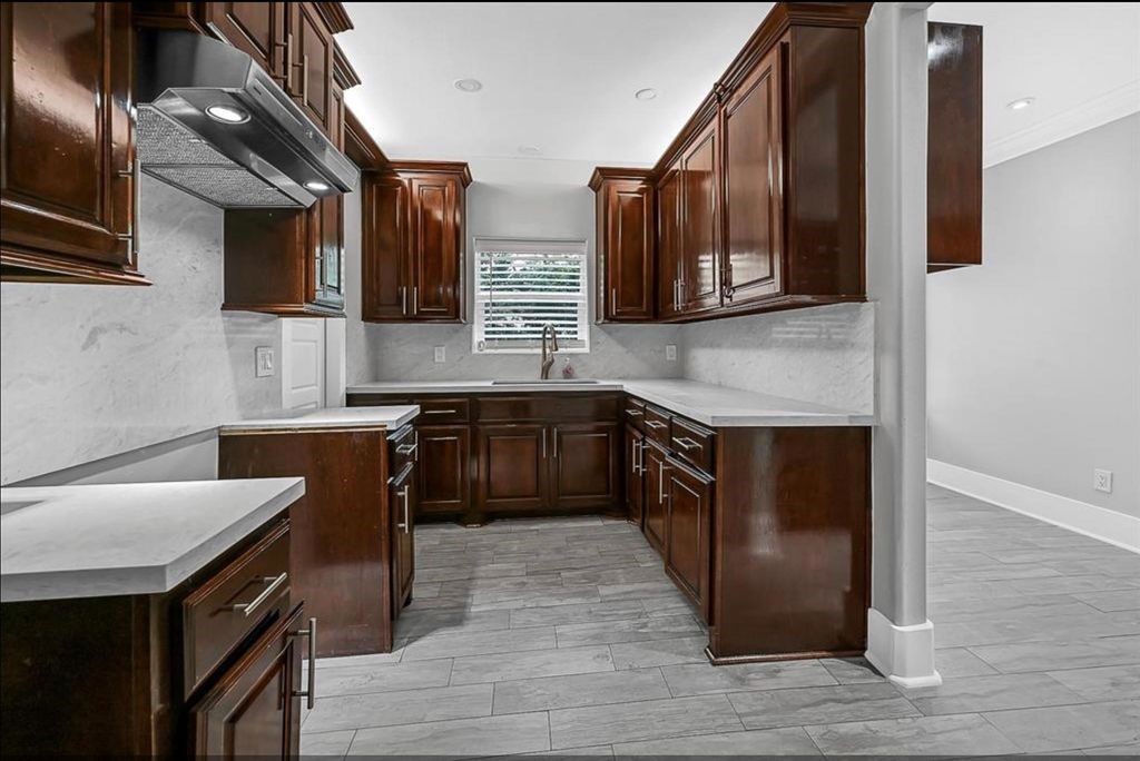 12430 Pecan Court Houston, TX 77013 - Photo 4 of 10 a kitchen with stainless steel appliances granite countertop a sink wooden cabinets and granite counter tops