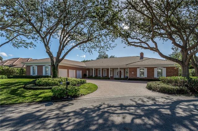 a front view of a house with a garden and trees