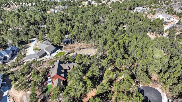 an aerial view of residential houses with outdoor space and trees