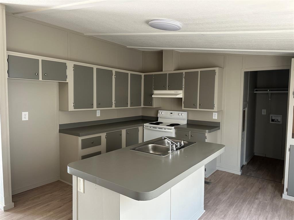 1109 Market Street Tye, TX 79563 - Photo 18 of 20 a kitchen with a sink cabinets and wooden floor
