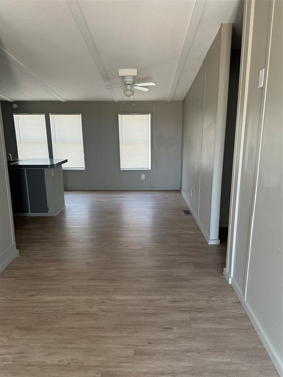1109 Market Street Tye, TX 79563 - Photo 4 of 20 an empty room with wooden floor and windows