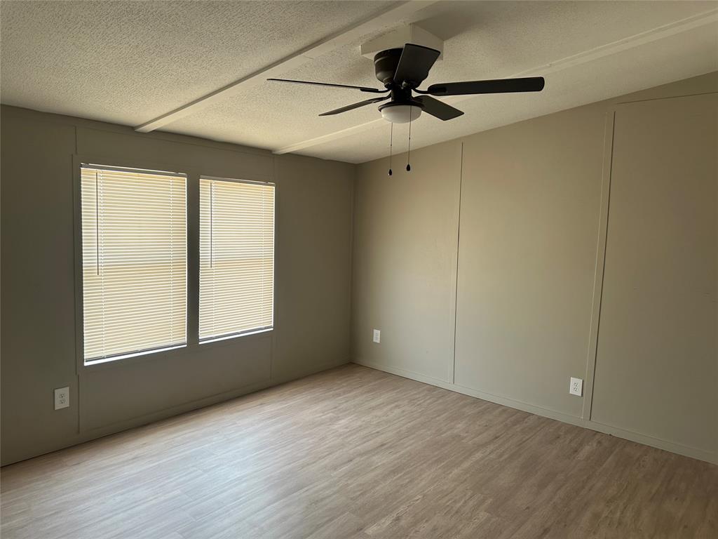 1109 Market Street Tye, TX 79563 - Photo 5 of 20 a view of an empty room with a window and wooden floor