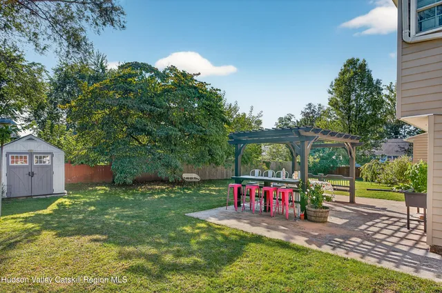 a view of a park with large trees and a barn