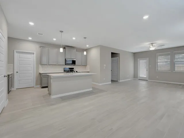 a view of kitchen with kitchen island a sink white cabinets and stainless steel appliances