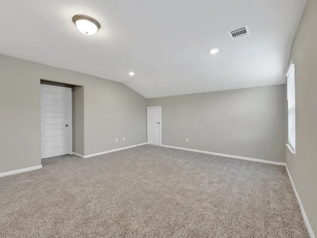 an empty room with an entryway and fan