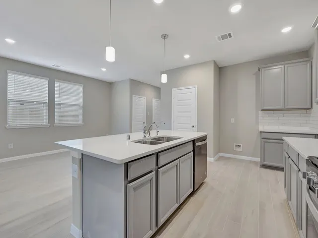 a kitchen with kitchen island a sink appliances and cabinets