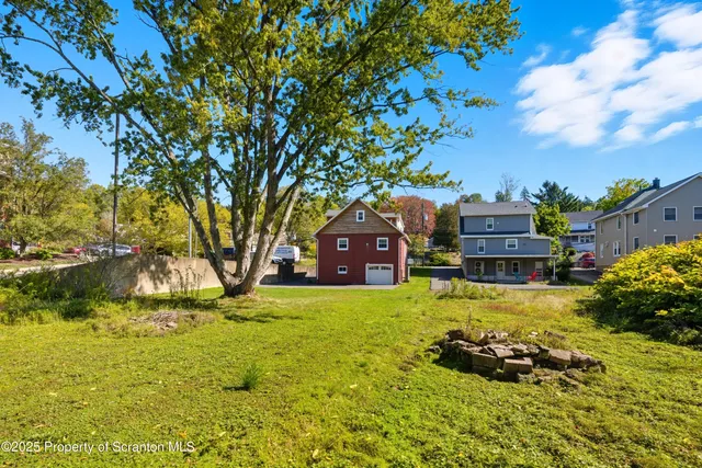 a tall yellow house with a yard in front of it