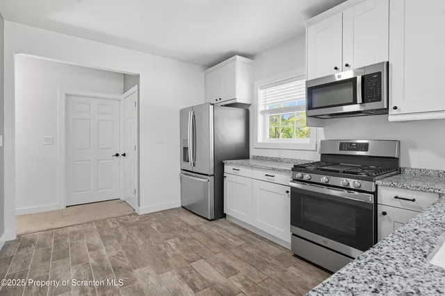 a kitchen with stainless steel appliances granite countertop a stove a refrigerator and a microwave