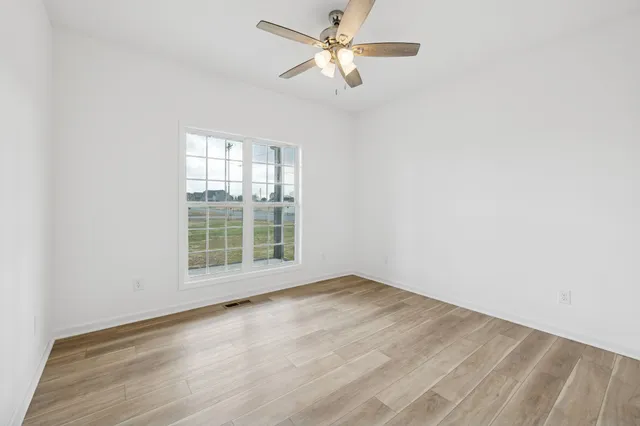 a view of a livingroom with wooden floor and a ceiling fan