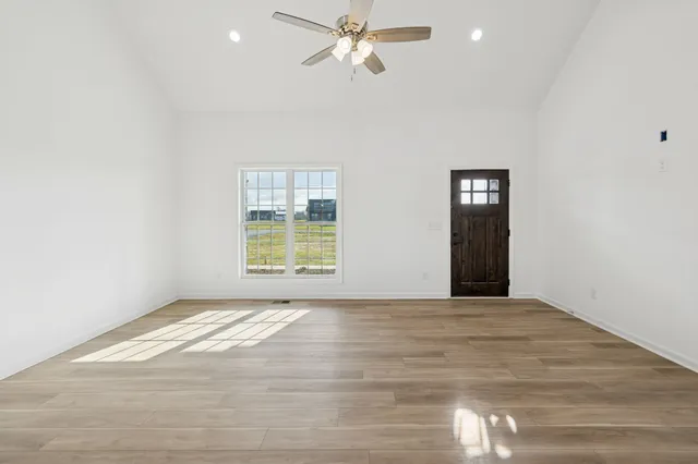 a kitchen with stainless steel appliances granite countertop a refrigerator a sink a stove and a wooden floors