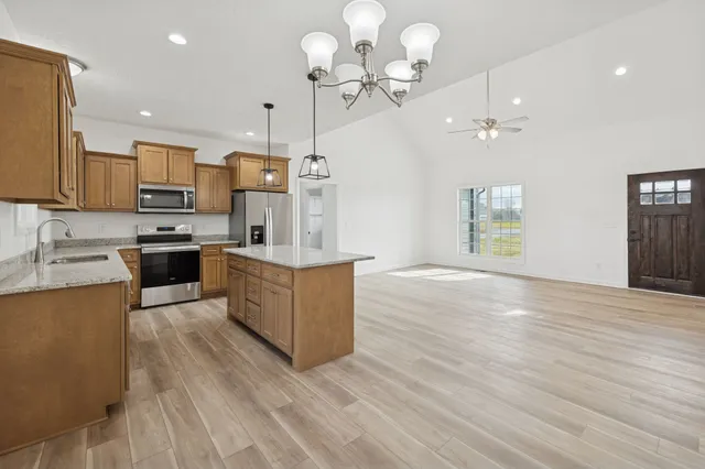 a kitchen with a kitchen island a stove and a wooden floor