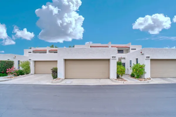 a front view of a house with a yard and a garage