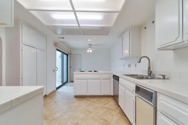a view of a big room with chandelier fan and windows