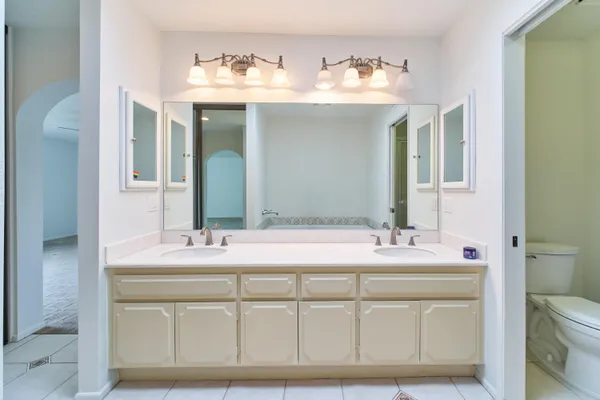 a spacious bathroom with a tub sink and mirror
