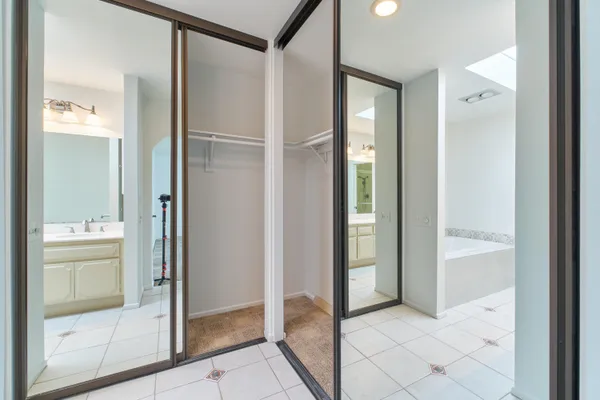 a kitchen with white cabinets and window
