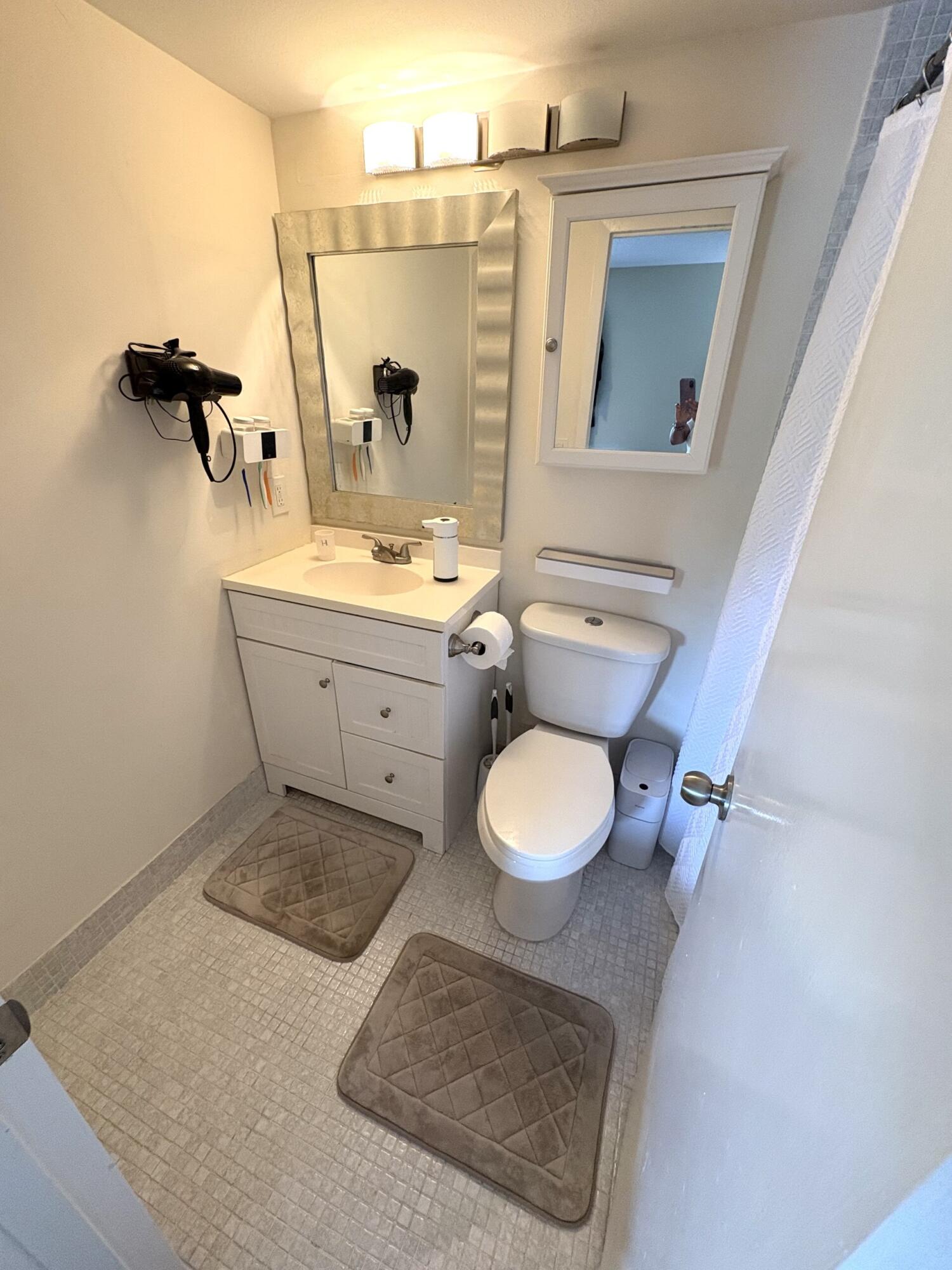 65 Preston F Boca Raton, FL 33434 - Photo 19 of 22 a bathroom with a sink a toilet and mirror